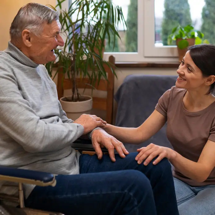 COHME caregiver at home with an elderly man using a wheelchair