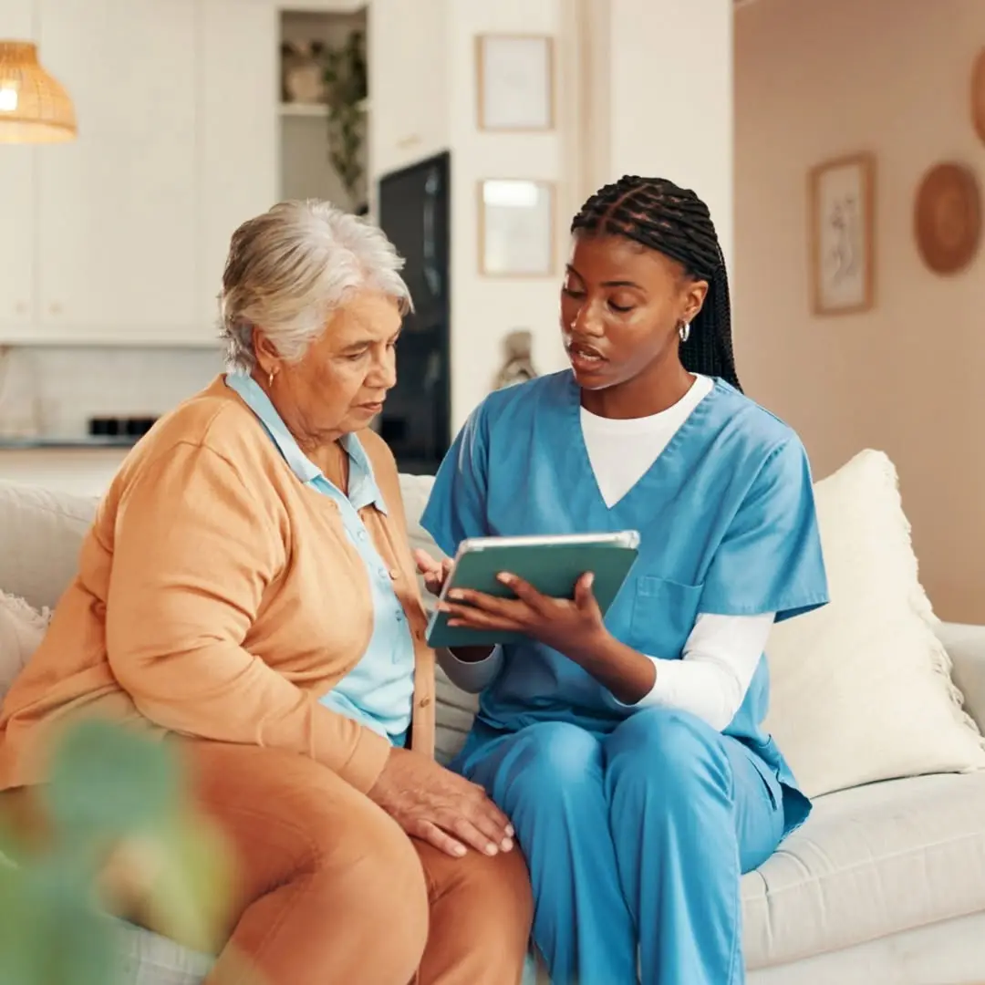 Home health aide reviewing a care plan with an elderly client at home
